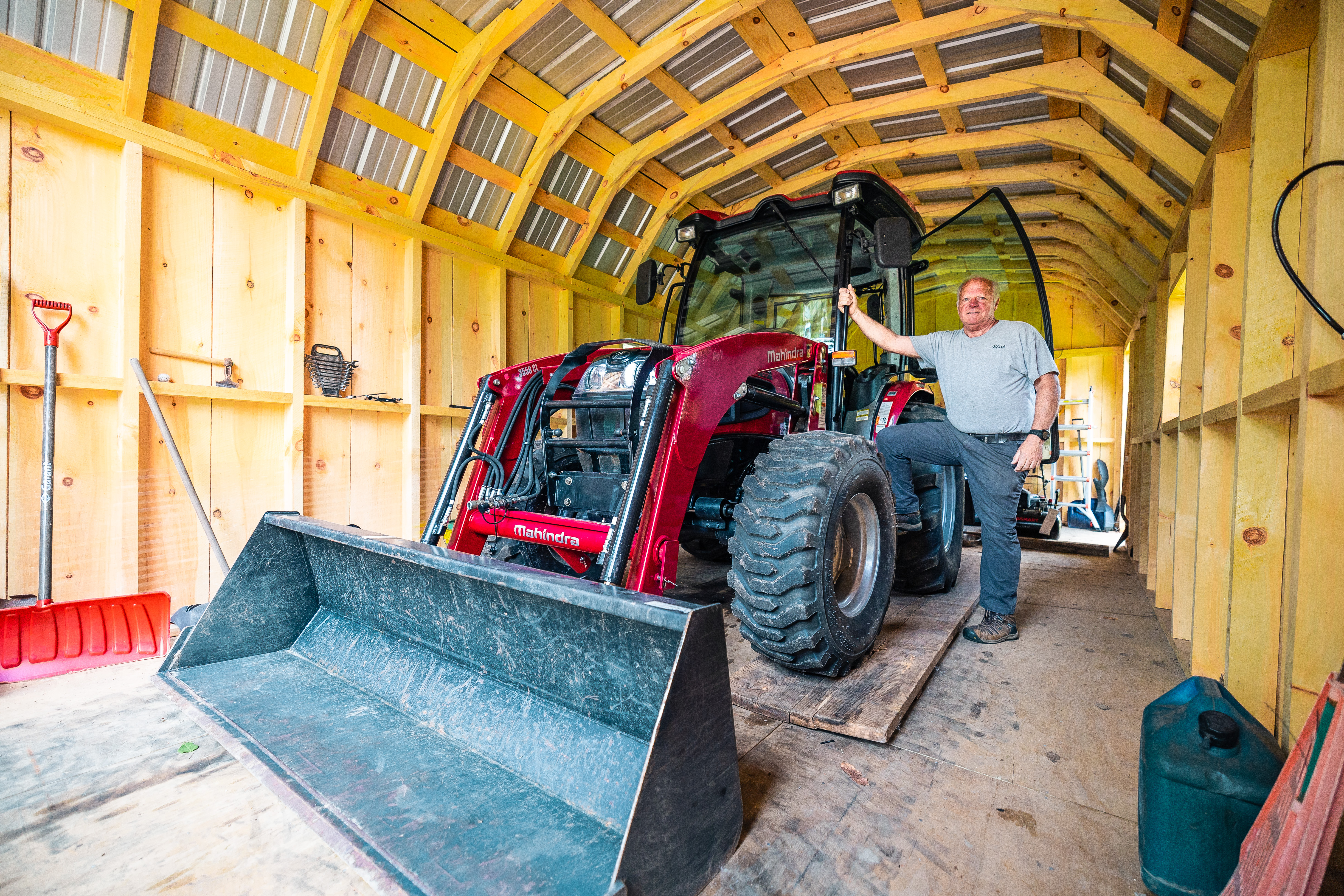 Member standing next to the tractor he was able to buy because of Adirondack Regional Federal Credit Union