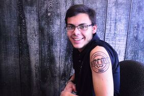 Garrett Kopp of Birch Boys showing off his tattoo of the company logo, on his upper bicep.