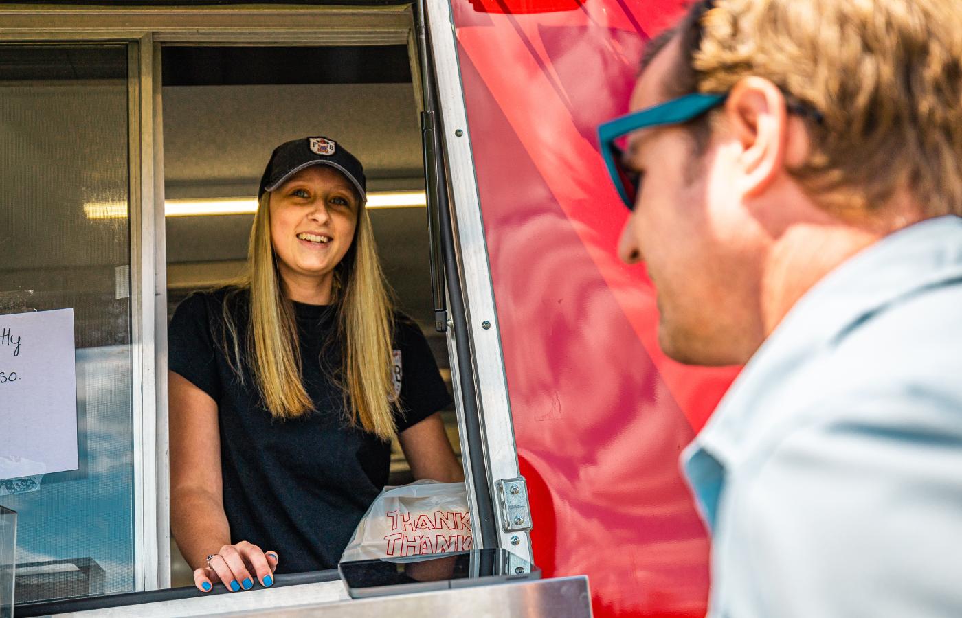 Customer visiting a food truck in Tupper Lake, employed by a student