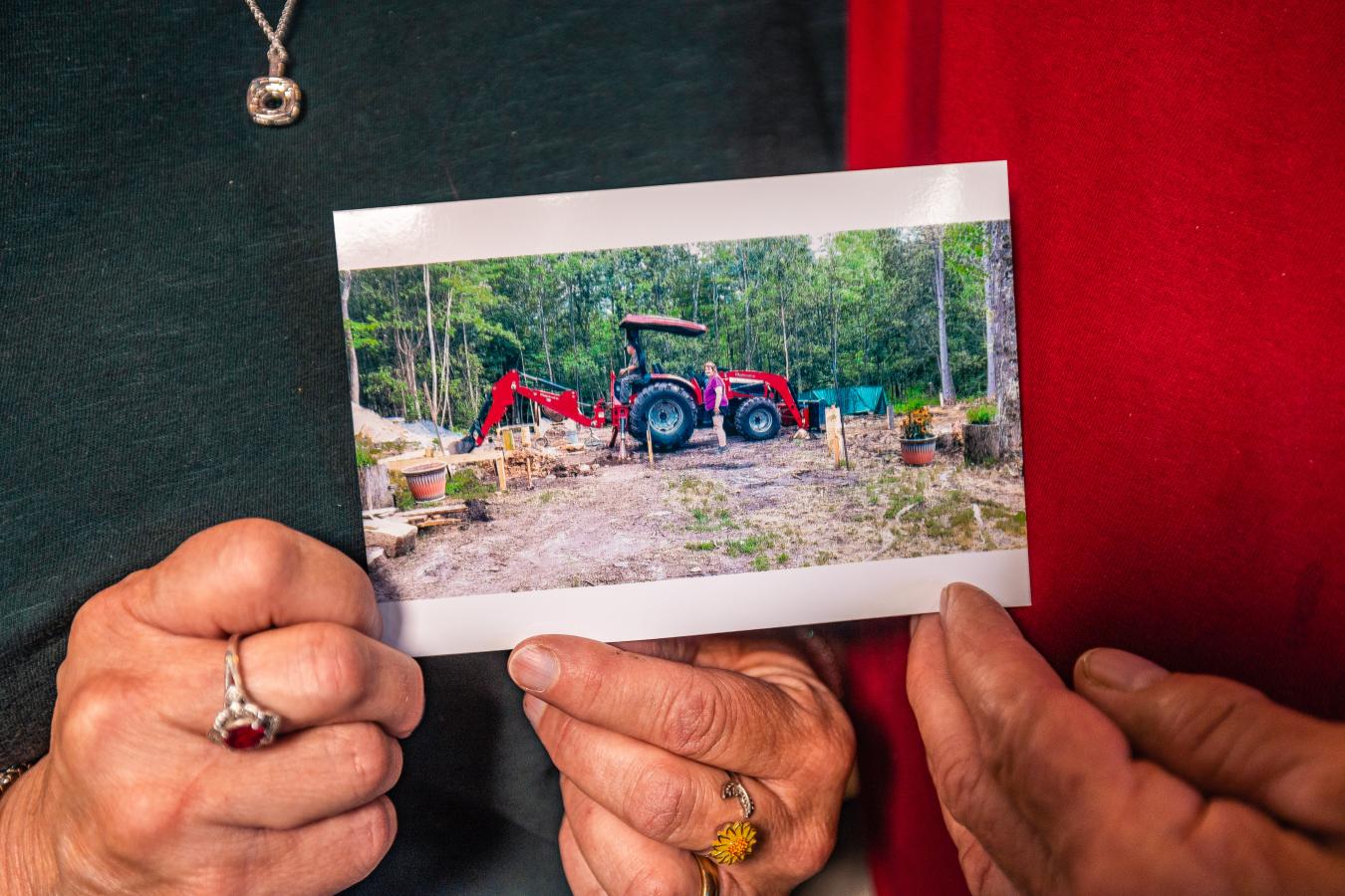 couple holding an image of their new tractor