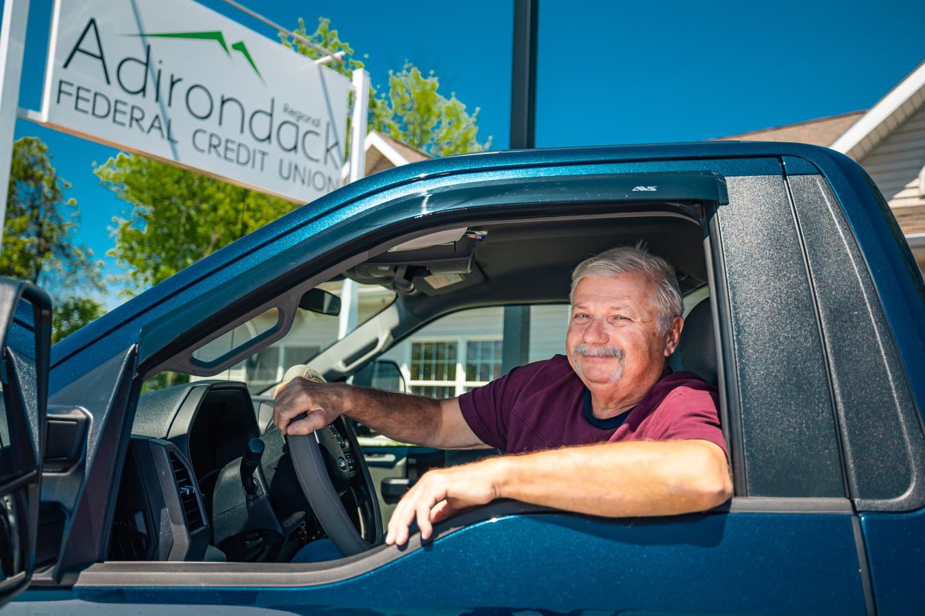 Credit Union member behind the wheel of his new truck that he purchased with a truck loan through Adirondack Regional Federal Credit Union