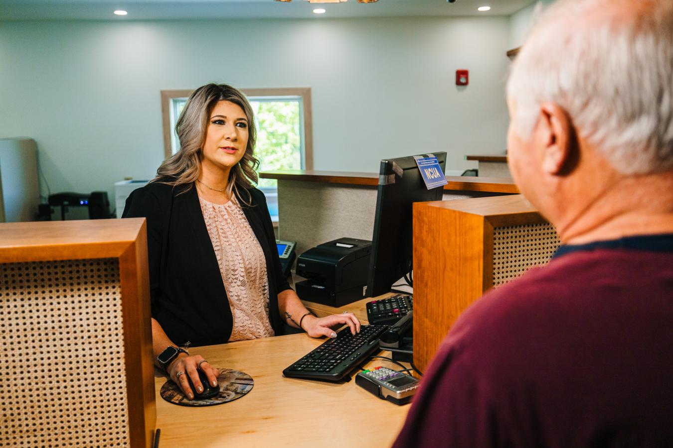 credit union staff helping a member with a report about a scam attempt