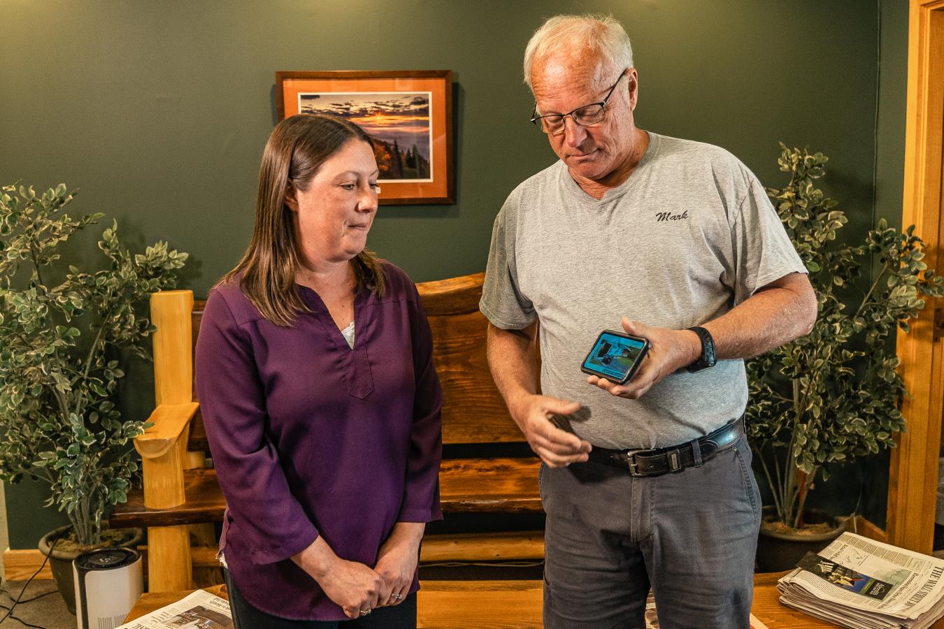 credit union teller reviewing a members mobile phone with them