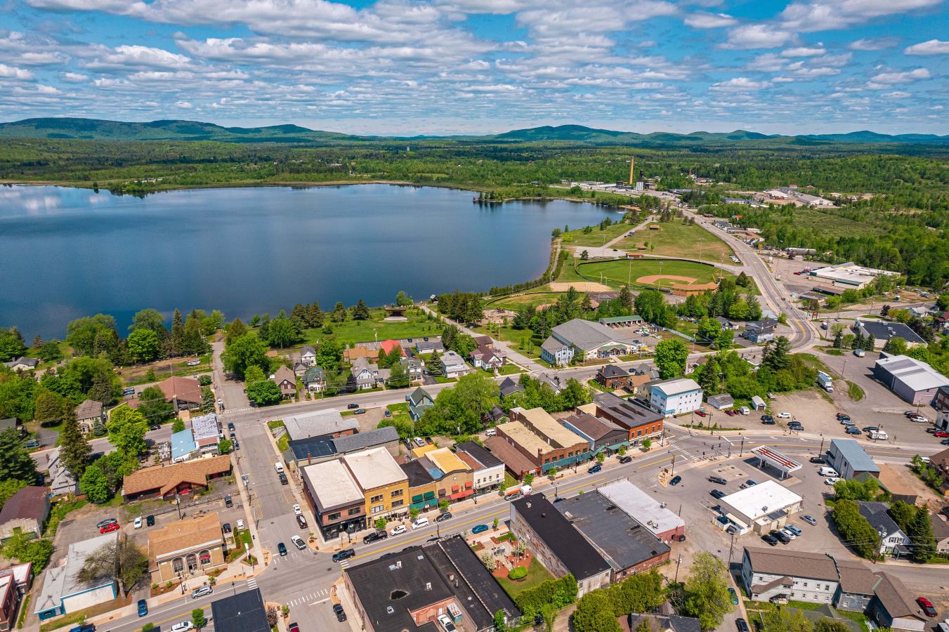 A stunning view of downtown Tupper Lake, NY featuring Main Street and beautiful Raquette Pond.