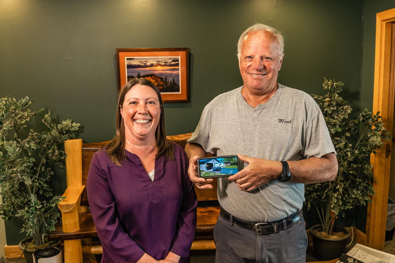 A financial counselor, and a member holding a photo of an RV they bought through a loan from Adirondack Regional Federal Credit Union