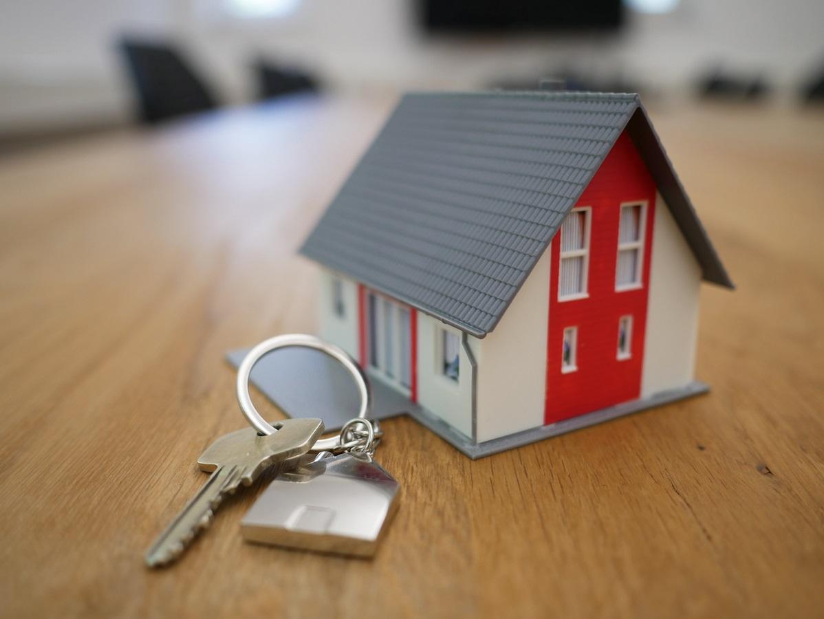 Small toy house next to a house key.