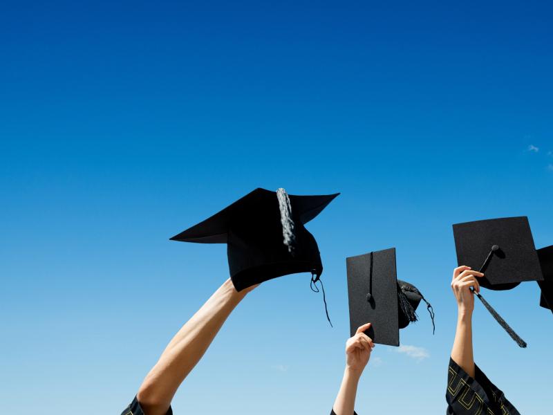 students holding graduation caps