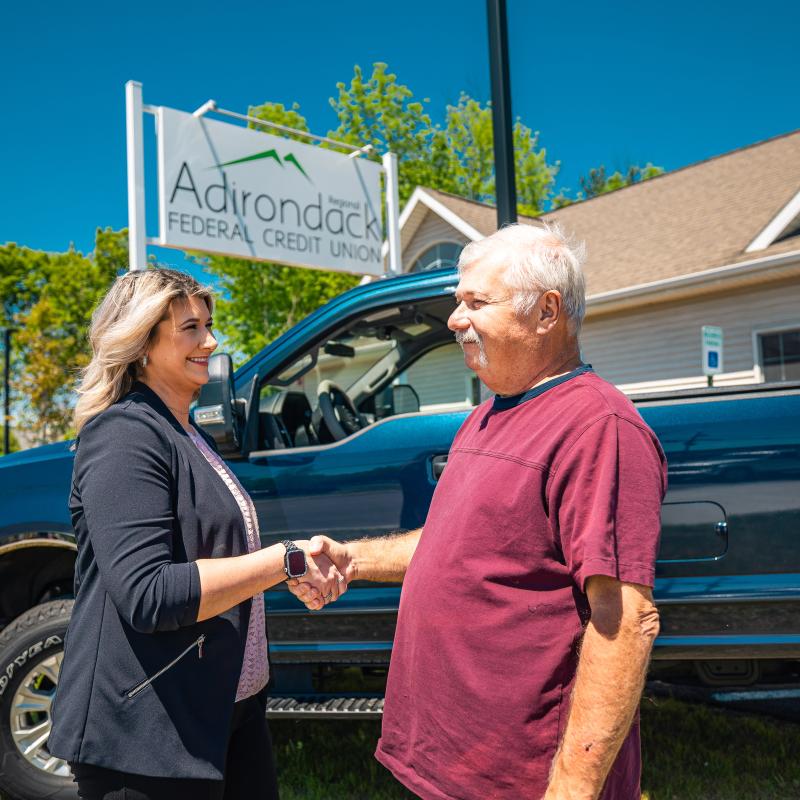 Loan officer shaking hands with the owner of a new truck purchased with a truck loan from Adirondack Regional Federal Credit Union