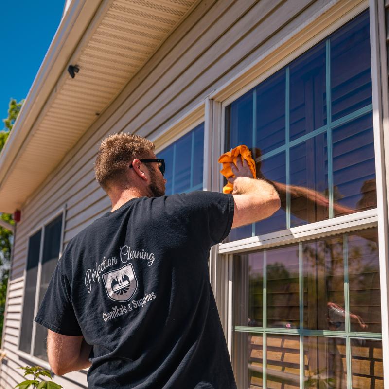 Local business credit union member, Perfection Cleaning, washing the windows of Adirondack Regional Federal Credit Unions Plattsburgh branch 