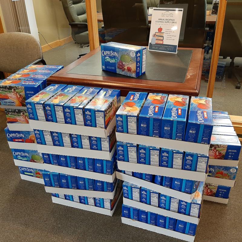 stacks of juice boxes being donated to local tupper lake schools