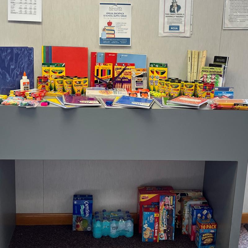 an overflowing table of crayons, books, and school supplies collected in tupper lake ny