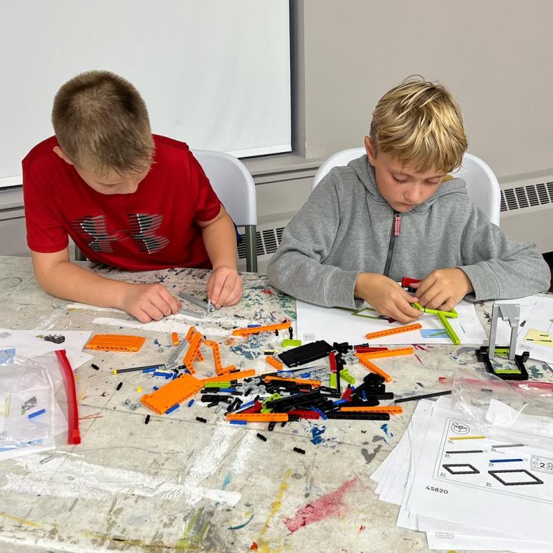 Two children assembling LEGO building blocks. 